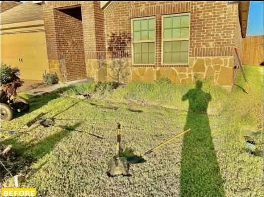Same foundation bed before landscaping - overgrown grass and no defined planting area