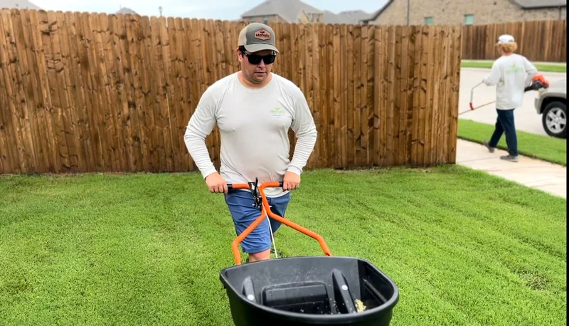 Crew member clearing leaves with a backpack blower