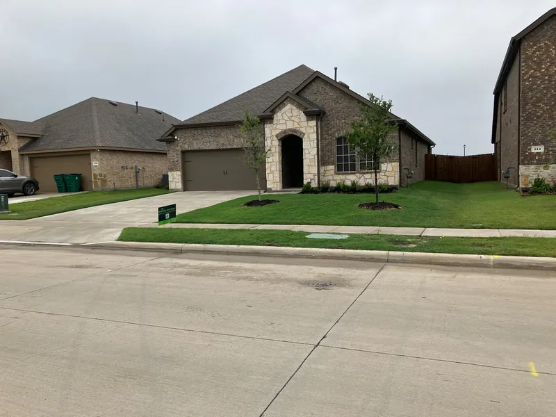 New-build home with a fresh Mahalic and Sons yard sign and manicured front lawn