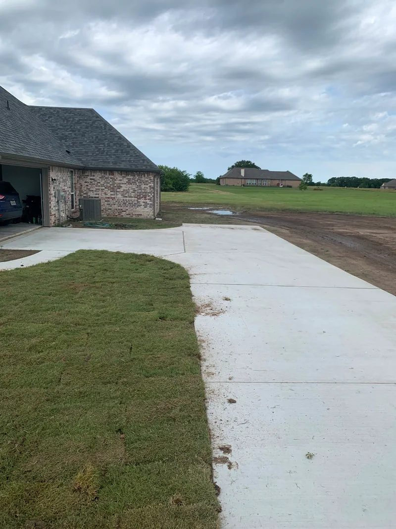 Wide street view of a mowed North Texas neighborhood lawn
